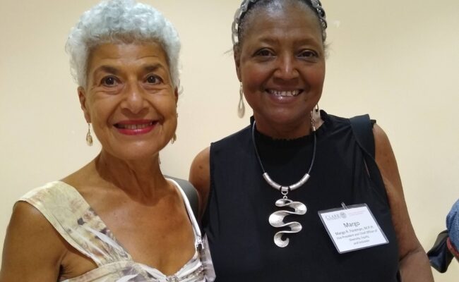 Photo of two women at the "can i touch it?" Performance and Clark Reception