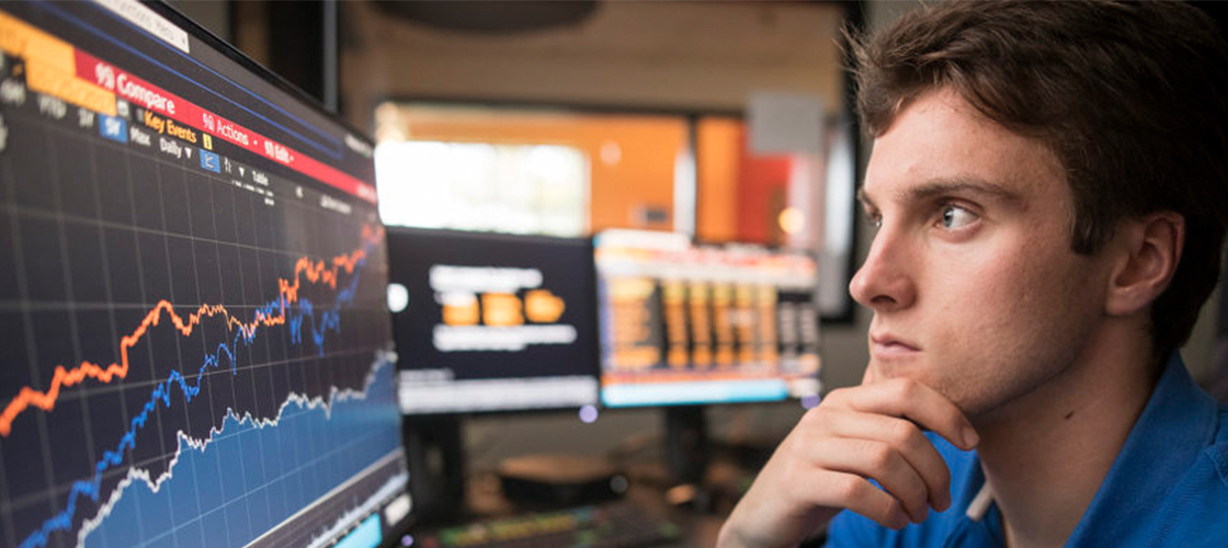 Student looking at stock market graph on computer