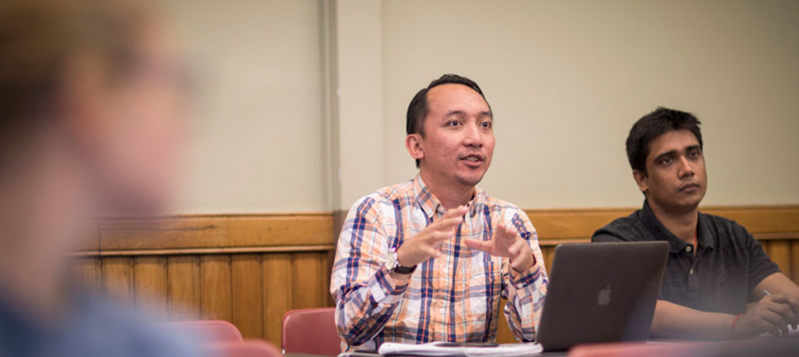 Student gesturing with hands and talking to class