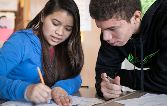 two students helping each other with homework