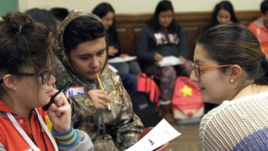 female student turned around talking to another student in cl