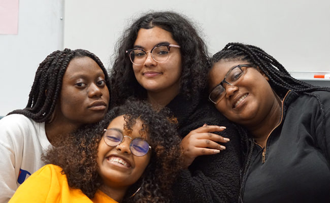 four female students hugging each other