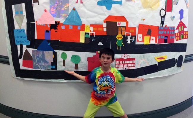 young boy standing in front of poster