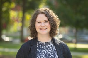 Headshot of Dr. Kathleen Williamson, in front of blurred background in Clark University's red square