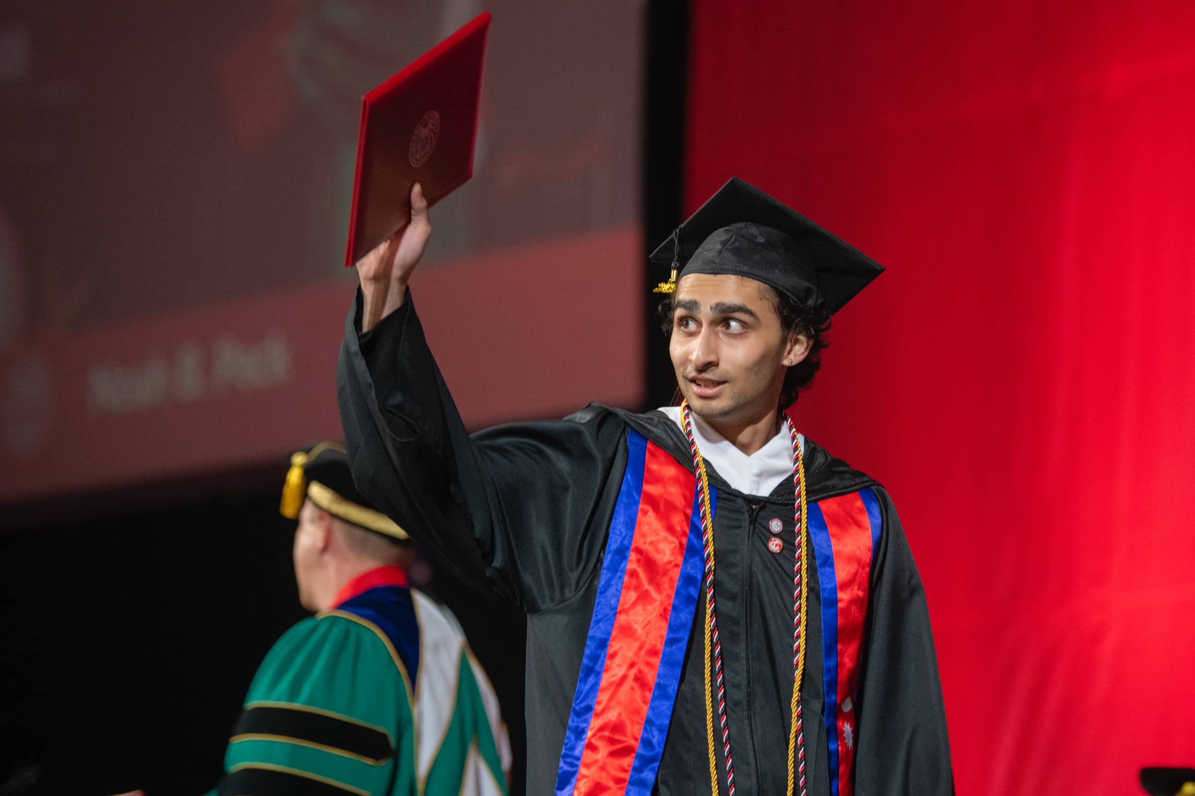 a graduate shows his newly acquired diploma