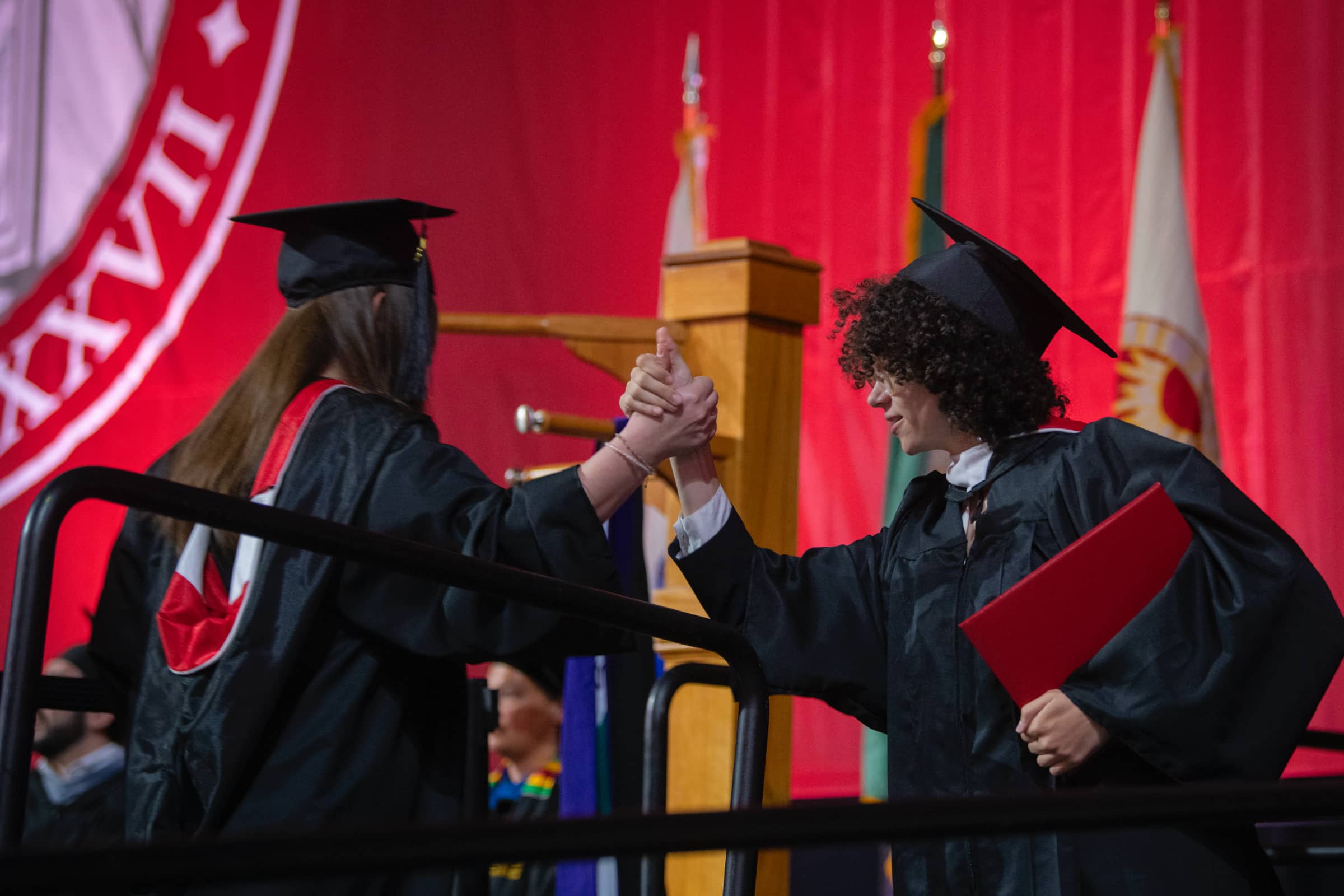 two graduates congratulate each other