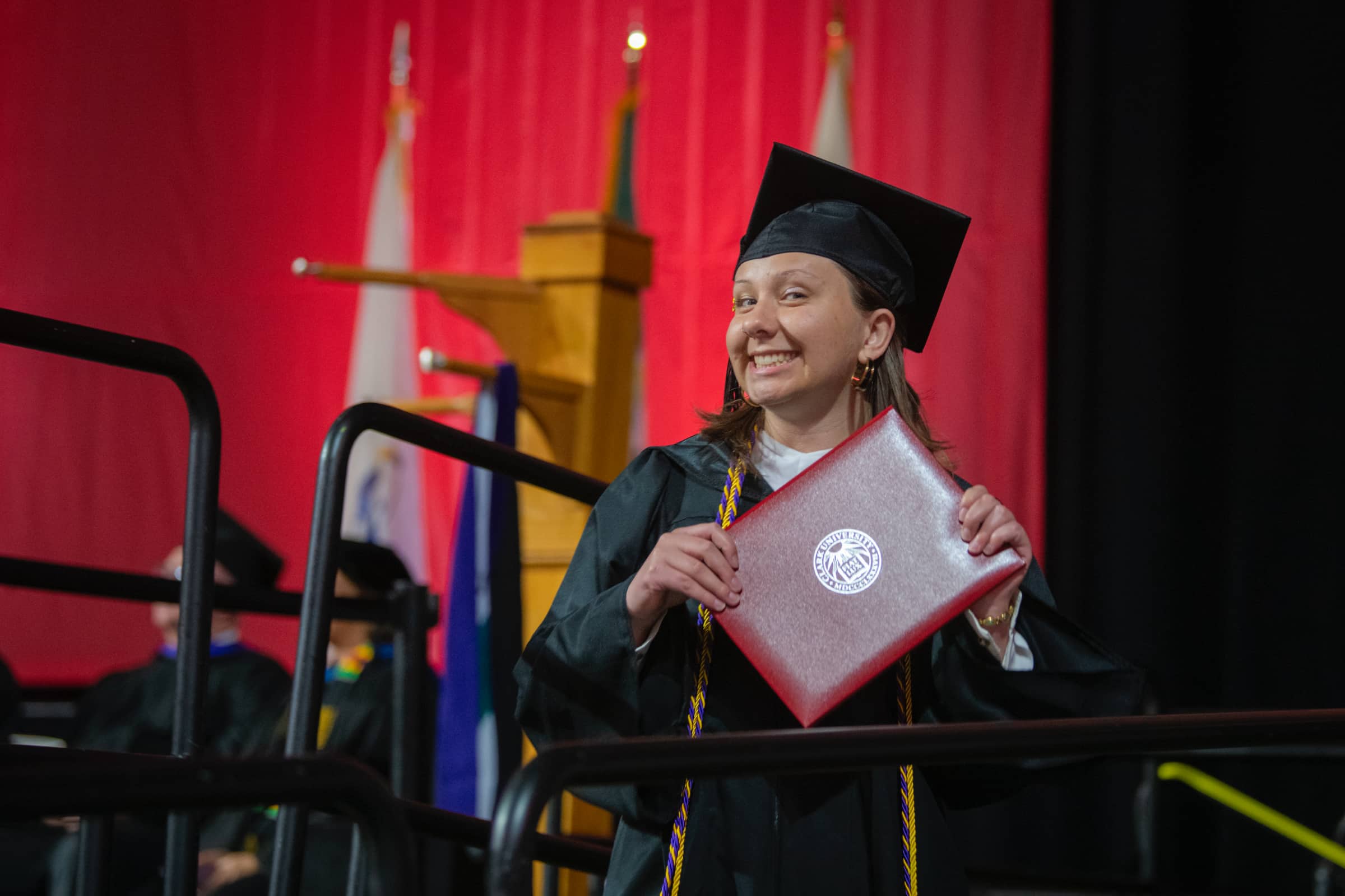 a graduate shows her newly acquired diploma