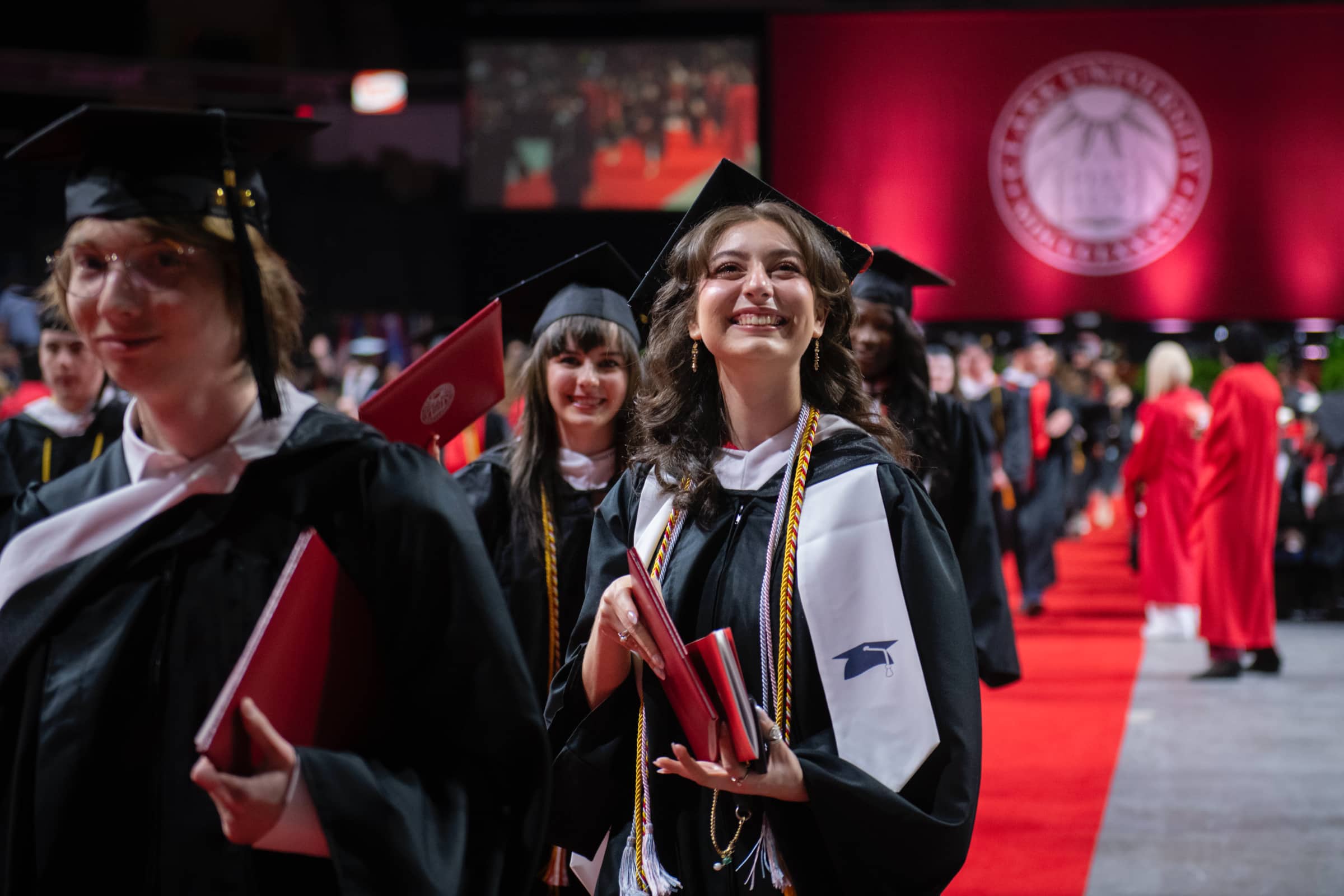 graduates leave the ceremony with diplomas in hand