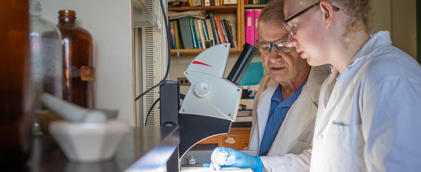 Student working with professor in chemistry lab