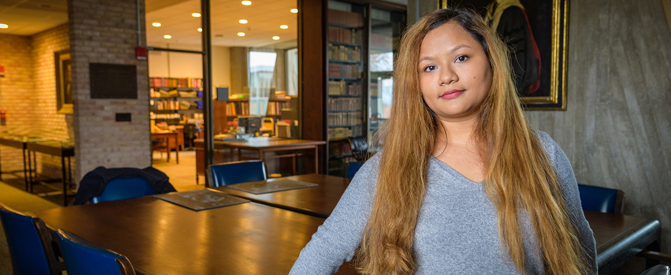 economnics intern student posing in library