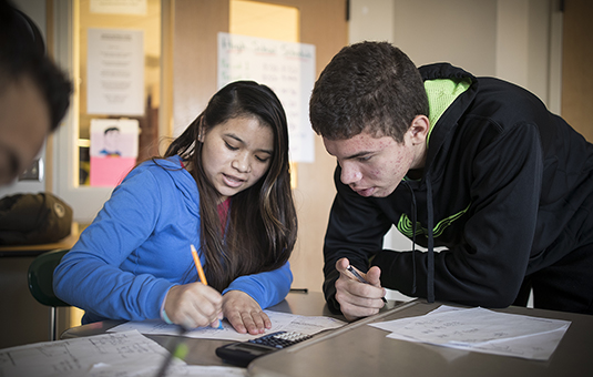 two students helping each other with homework