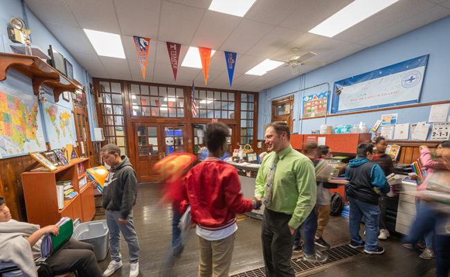 teacher talking in hall way with students