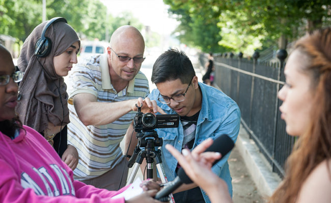 teacher showing student how to handle video equipment