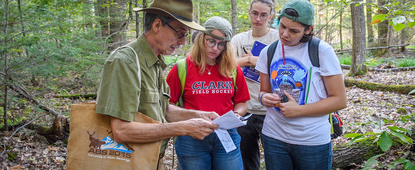 Professor and students in woods
