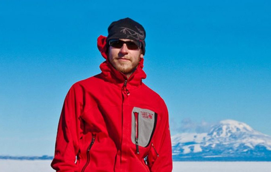 Paul Siple in arctic with mountains in background