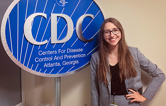 Keegan Daugherty standing in front of sign for Centers for Disease Control