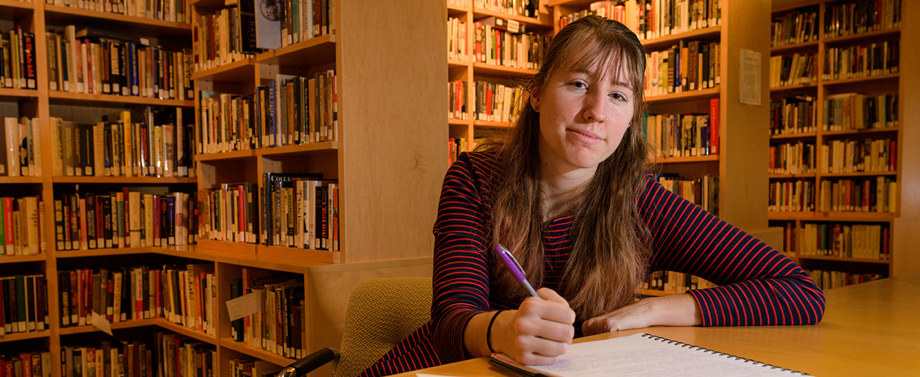Student writing at desk
