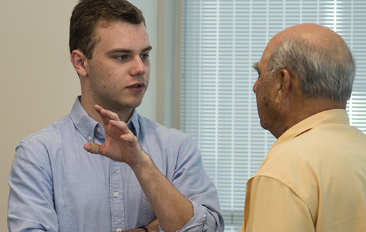 Student Spencer Cronin talking to alumnu