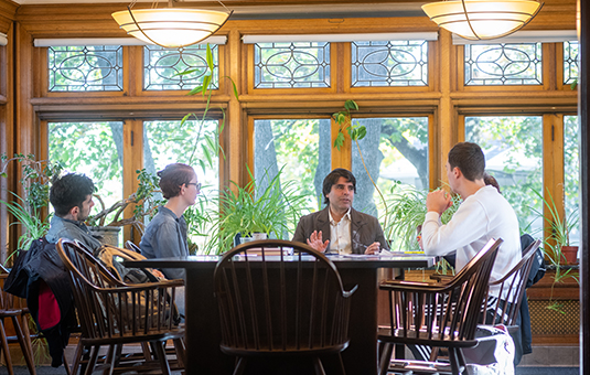 students and professor around table