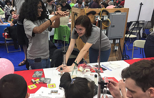 Physics students doing experiments at science fair