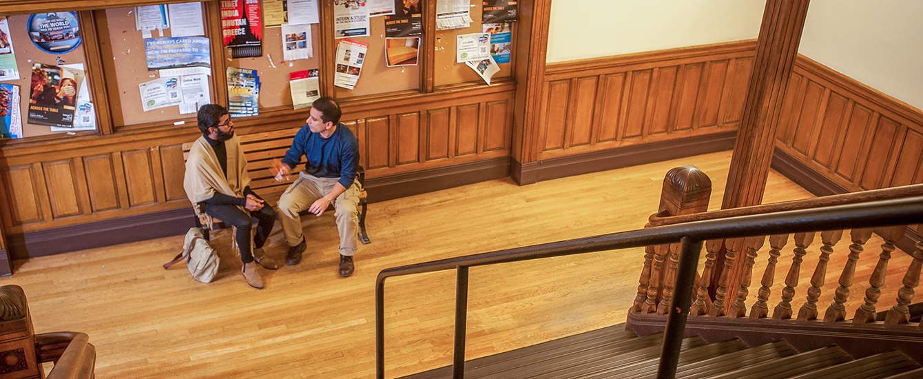 two faculty members talking in hallwa