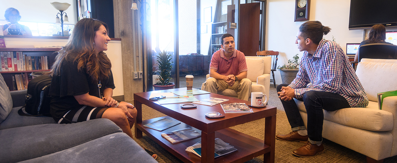 students sitting in living room setting talking
