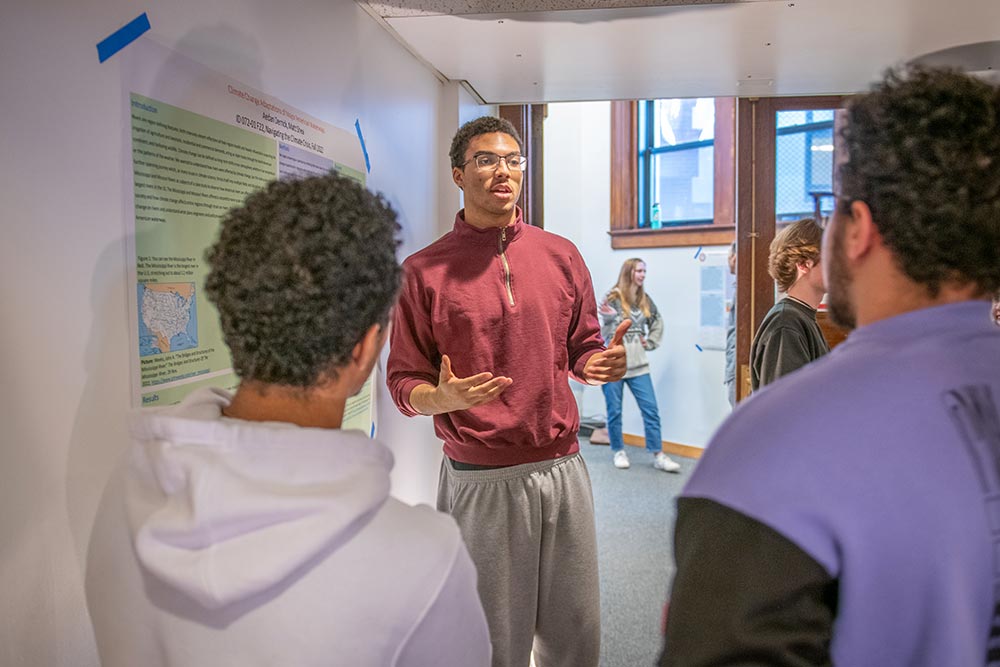 Aedan Derrick present at the culminating poster salon for a research project he worked on with Matt Shea ’26, “Climate Change Adaptations of Major American Waterways.”