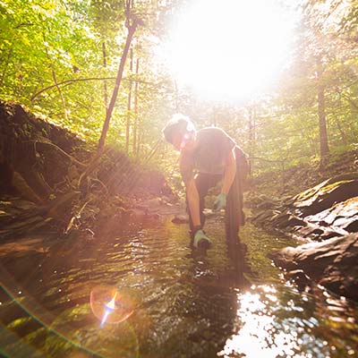 Abby Beilman gathering water samples in Coal Mine Brook