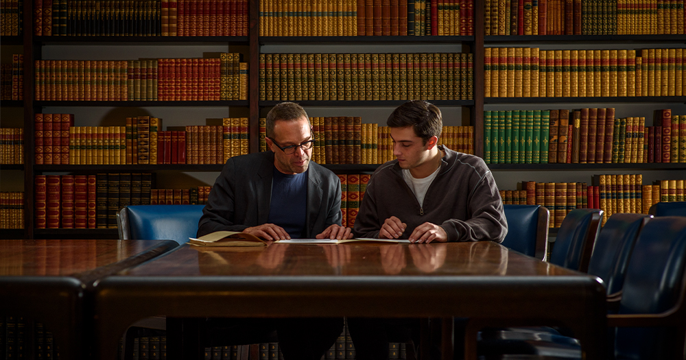 Professor and student looking at books