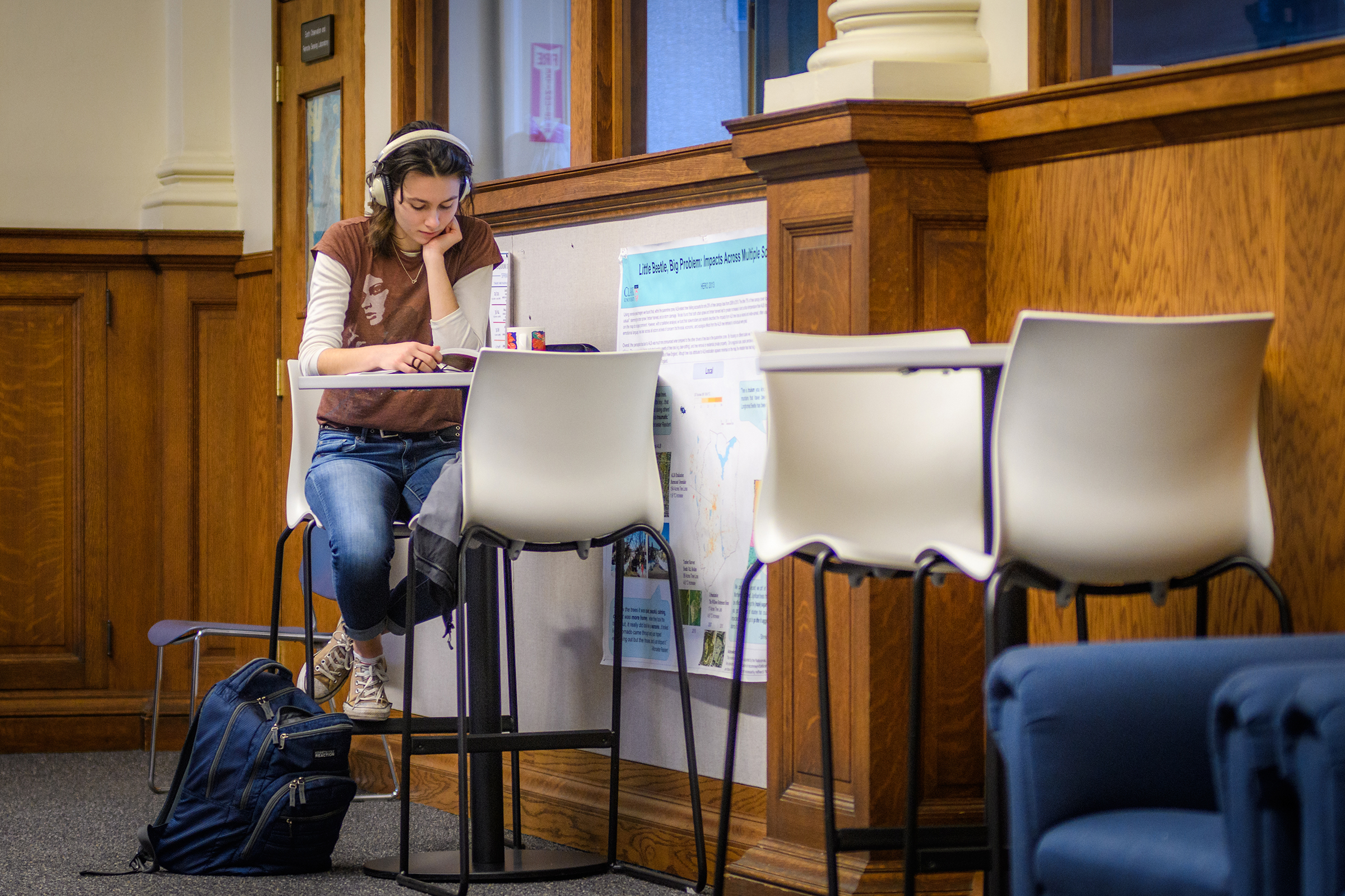 Geography Building - student sitting in chairs/table in hallway