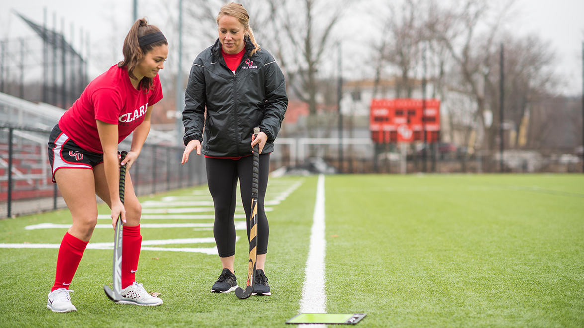 Dolan Field House - field hockey coach working with student