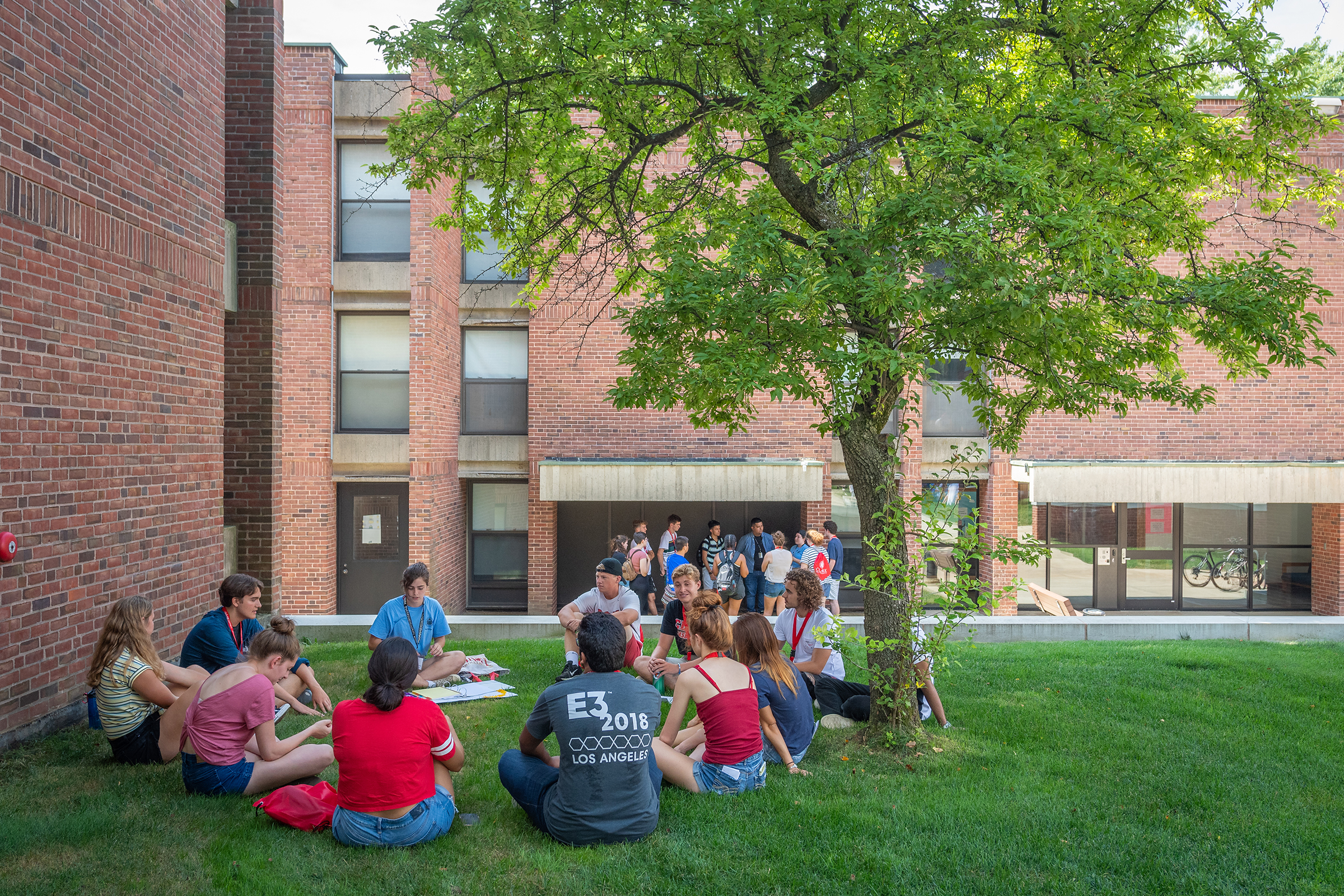 Hughes Hall - students sitting on green