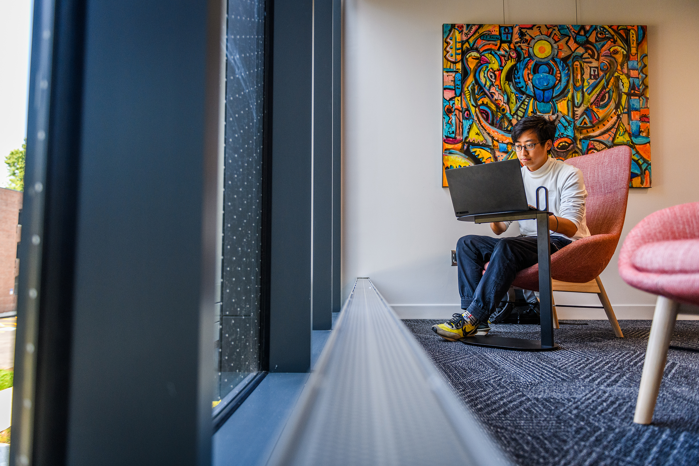 Center for Media Arts, Computing, and Design Building - student sitting in lounge area