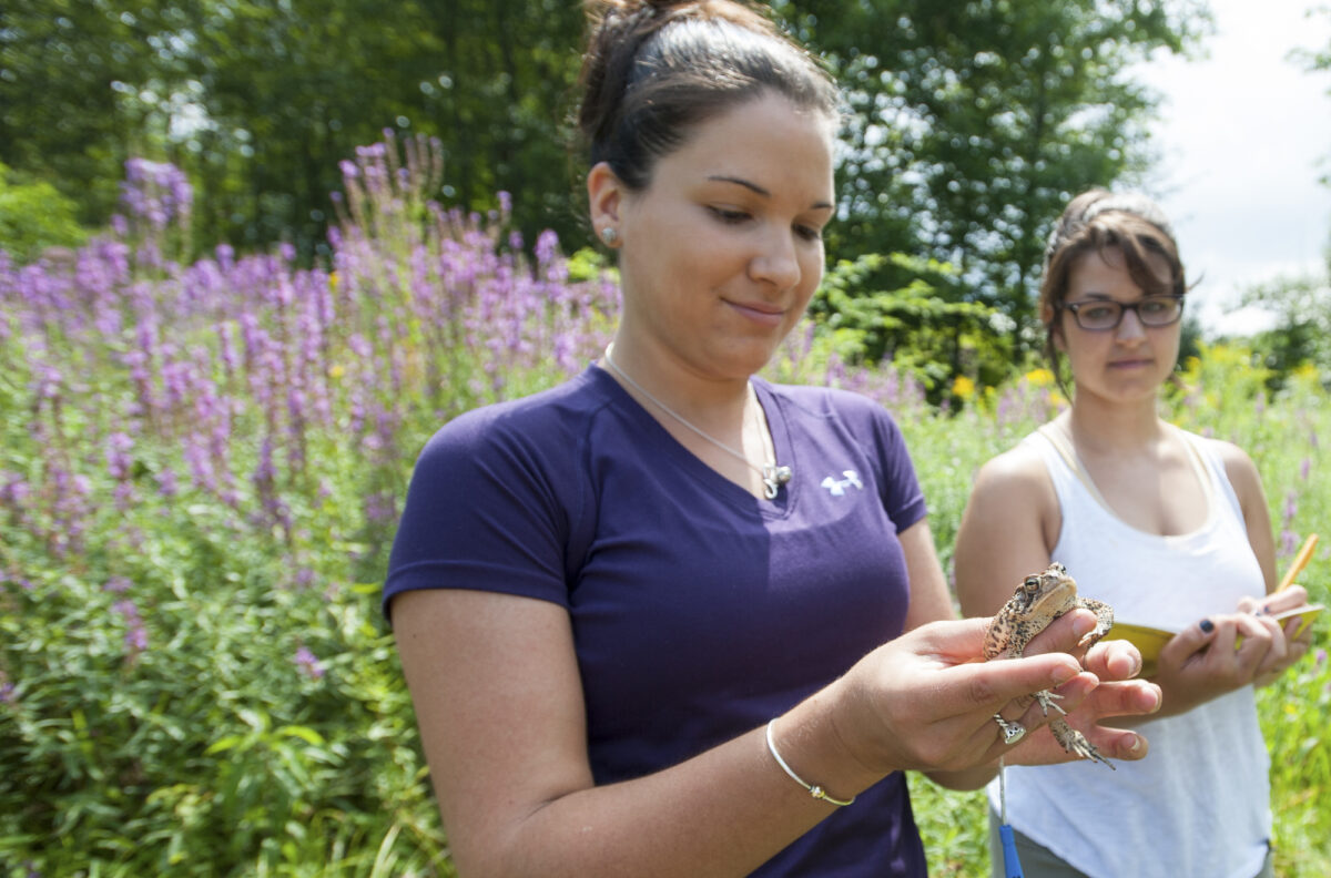 Student holding a frog