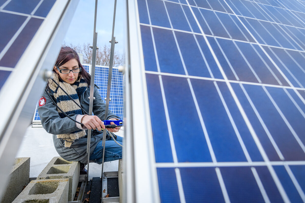 Megan McIntyre works on a solar pane