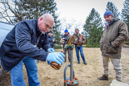 Collecting water sample in Uxbridge, Mass.