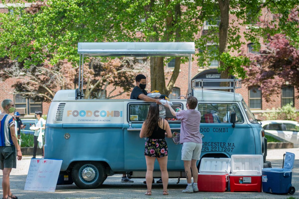 students serve food from a Volkswagen food tru
