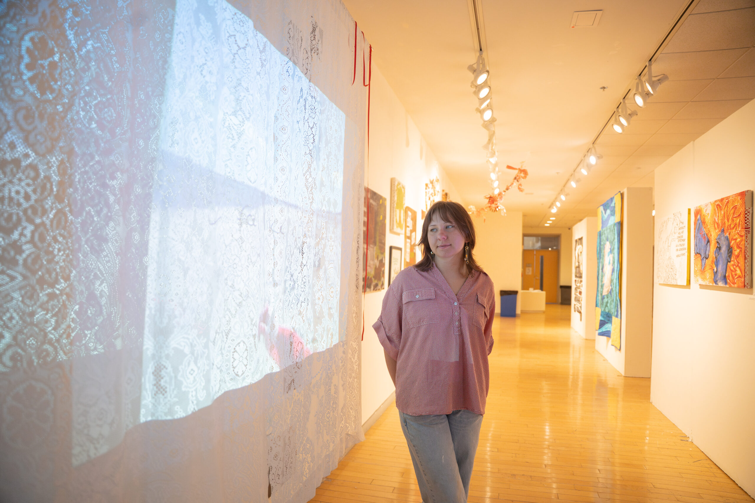 student in hallway with art