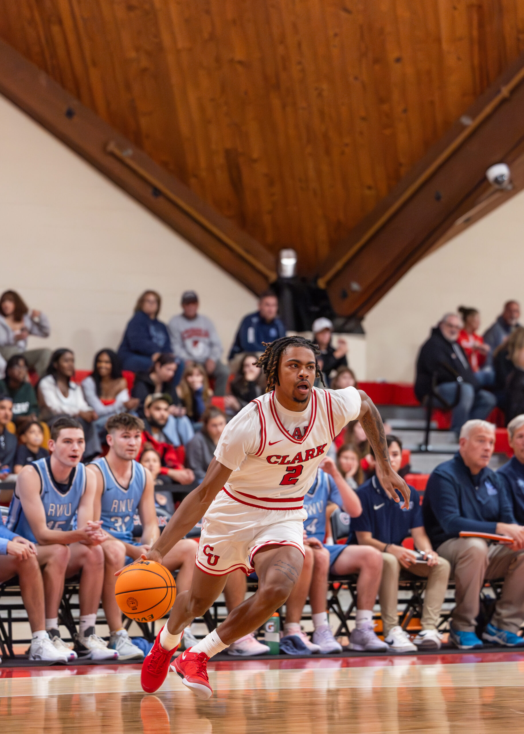 student dribbling basketball during game