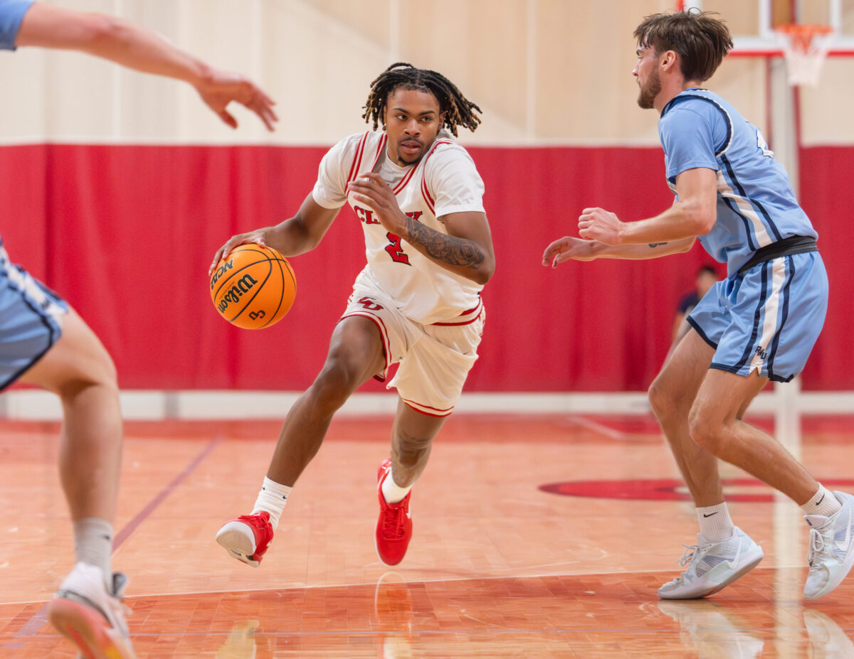 student dribbling basketball during game