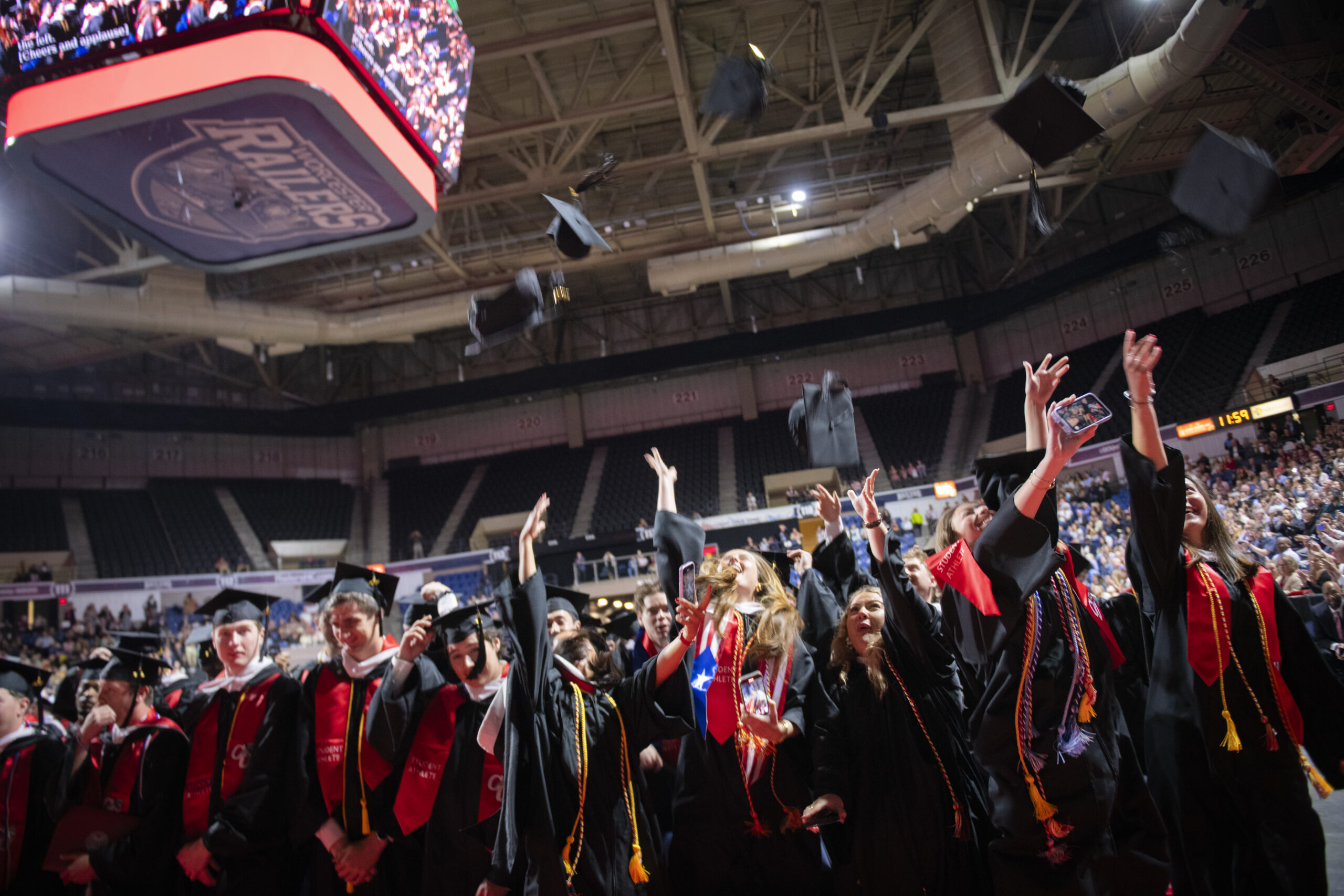 Clark University students toss graduation caps in the air after receiving their diplomas at Commencement