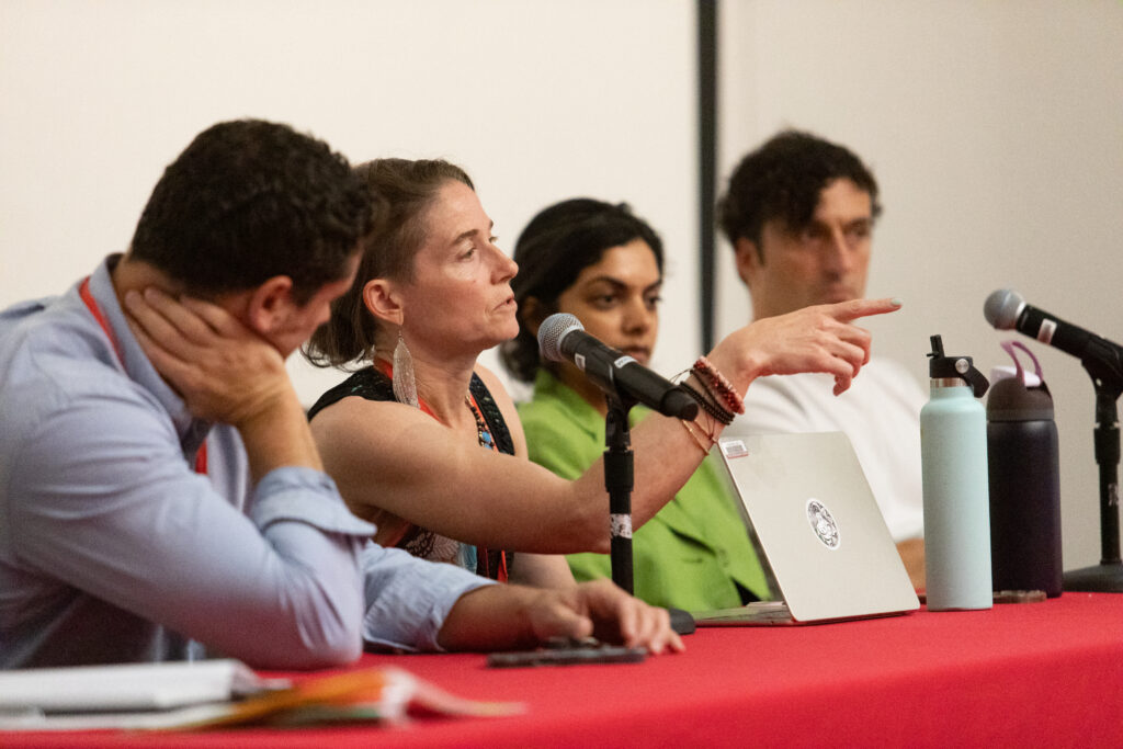 four people sitting at table with microphone