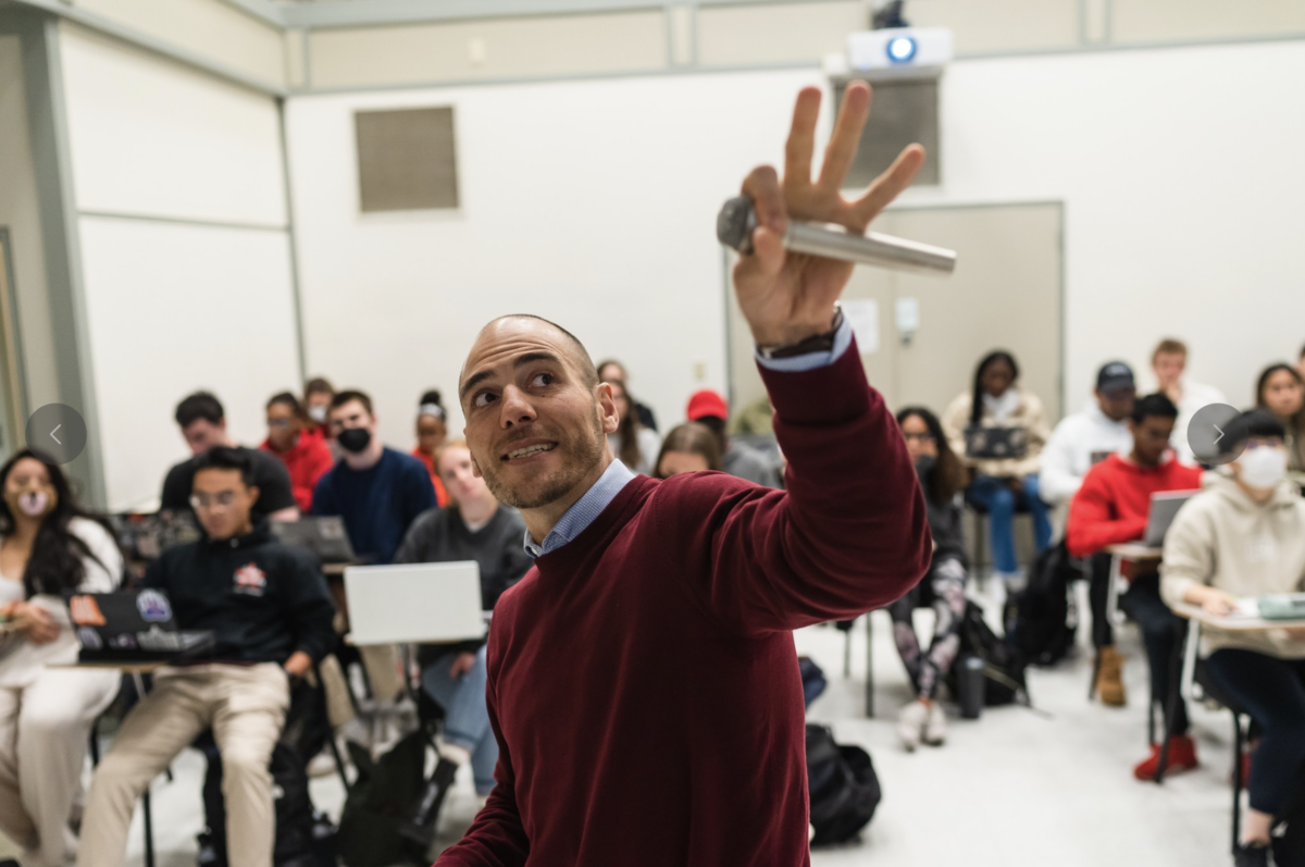 Professor John Freyermuth in classroom holding microphone