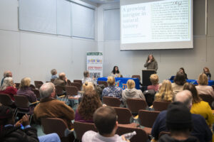 people listen to student making presentation