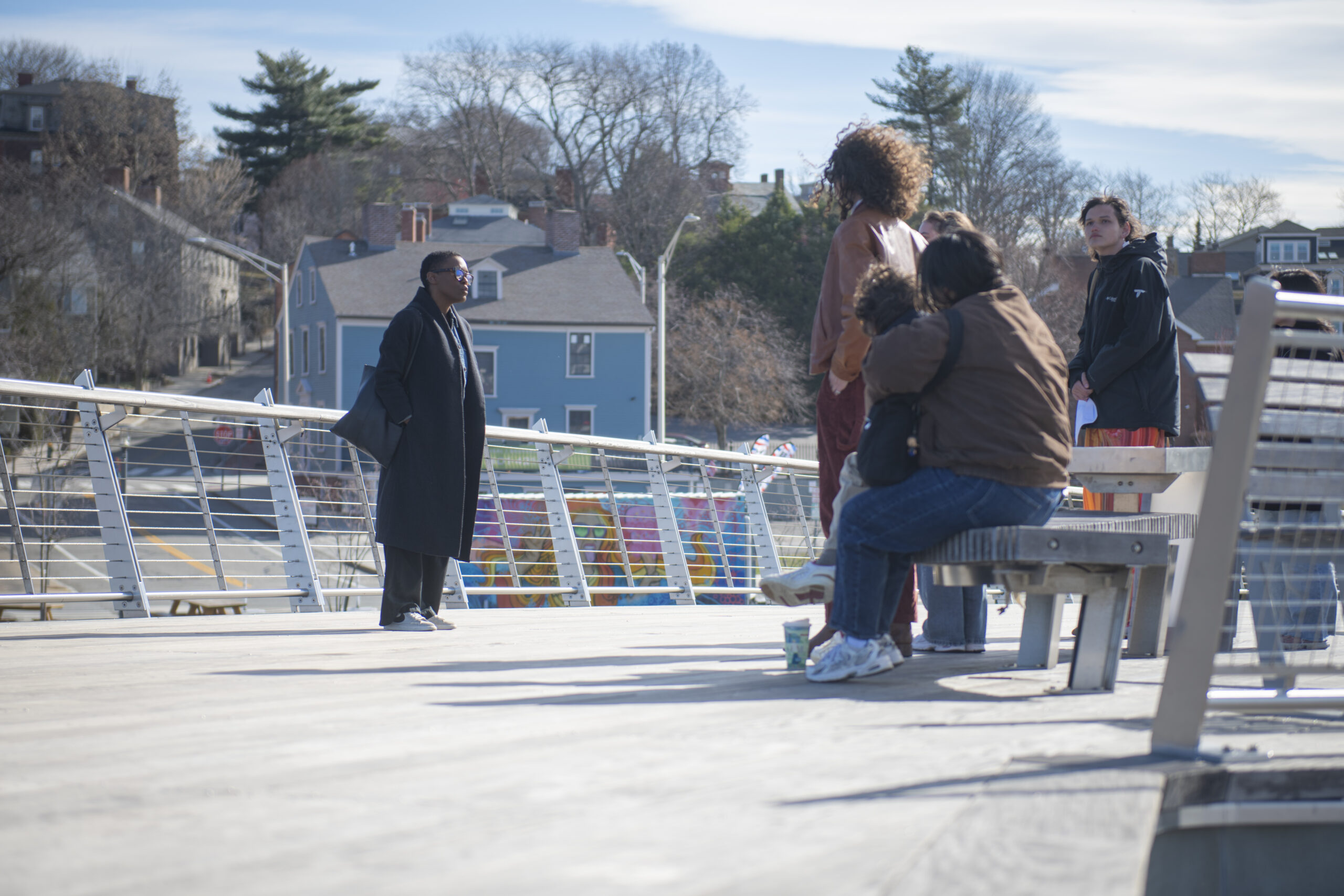 professor talks to students on bridge