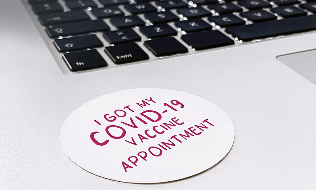 Sticker on laptop saying "I got my COVID-19 vaccine appointment"