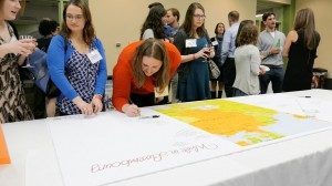 Leir Program alumni sign a map of The Grand Duchy of Luxembourg during the reunion.