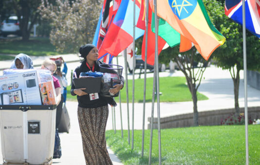 Student on campus with international flags on lawn