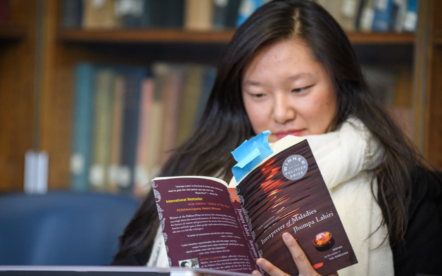 english student reading book in library