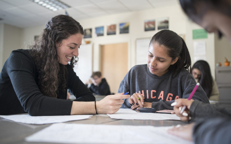 young student working with middle age student in class